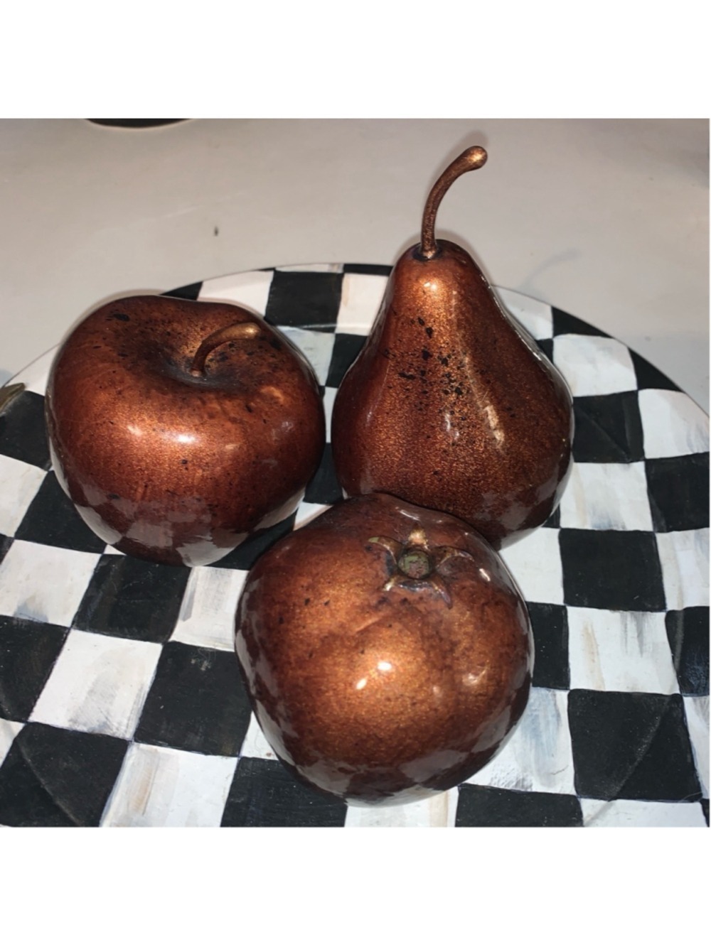 Three pieces of bronze coloured fake fruit